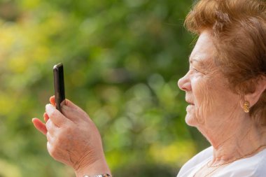 Dışarıda cep telefonu ya da akıllı telefon kullanan son sınıf öğrencisi.