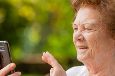 Dışarıda cep telefonu ya da akıllı telefon kullanan son sınıf öğrencisi.