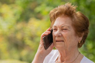 Dışarıda cep telefonu ya da akıllı telefon kullanan son sınıf öğrencisi.