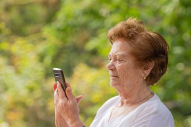 Dışarıda cep telefonu ya da akıllı telefon kullanan son sınıf öğrencisi.