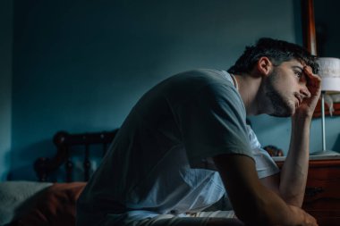 Evdeki genç adam endişeli veya düşünceli.