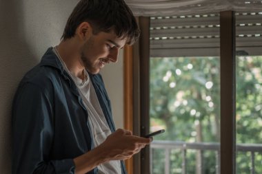 Evde cep telefonu ya da akıllı telefonu olan genç ya da genç bir adam