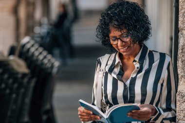 Siyah bir kadın haritayla sokaklarda dolaşıyor.