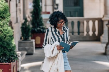 Siyah bir kadın haritayla sokaklarda dolaşıyor.