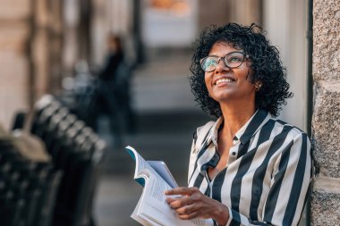 Siyah bir kadın haritayla sokaklarda dolaşıyor.