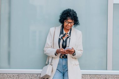 Duvarda cep telefonu olan bir kadın.