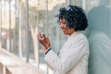 Duvarda cep telefonu olan bir kadın.