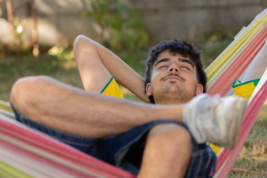 Yazın genç adam hamakta dinleniyor.