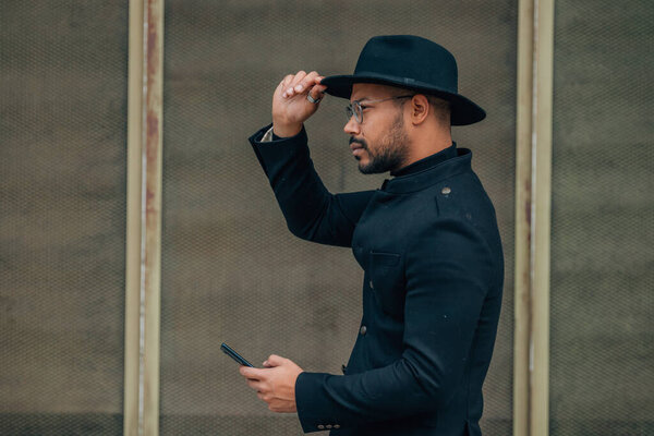 latin man with mobile phone on the street