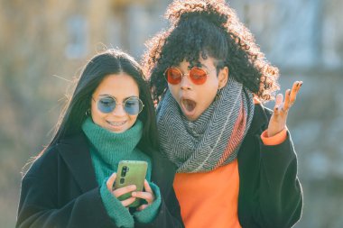 Sokaklarda cep telefonuna bakan çok ırklı gençler