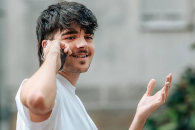 Sokakta cep telefonuyla konuşan genç bir adamın portresi.