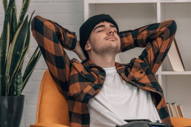 Genç adam evde dinleniyor.