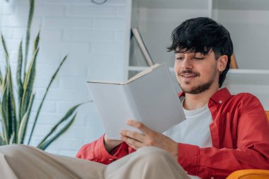 Genç adam ders kitabı okuyor.