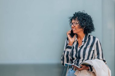 Sokaktaki kadın cep telefonu ve defteriyle