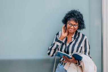 Sokaktaki kadın cep telefonu ve defteriyle