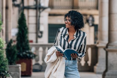 Afro-Amerikan Latin kadın şehir sokaklarında seyahat haritası taşıyor.