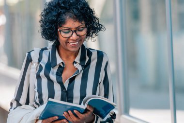 Afro-Amerikan Latin kadın şehir sokaklarında seyahat haritası taşıyor.