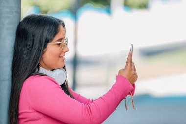 Sokakta cep telefonuna bakan bir kız.