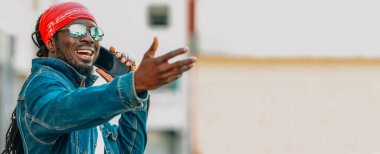 Sokakta cep telefonuyla konuşan Afrikalı bir adam