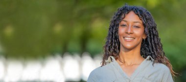 Açık havada gülümseyen genç Latin kız ya da kadın portresi