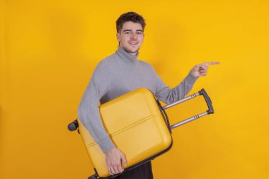 yalnız bir genç ya da öğrenci, elinde bavul ile