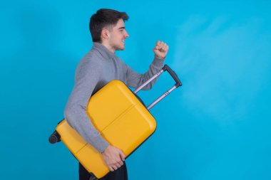 Renkli bavulu olan izole bir genç adam.