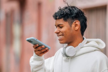 Cep telefonlu genç latin adam sesli mesaj gönderiyor.