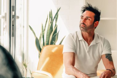 Evdeki çekici adam düşünceli ya da kararlı görünüyor.