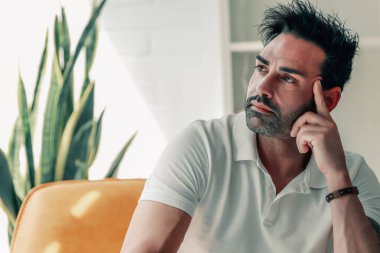 Evdeki çekici adam düşünceli ya da kararlı görünüyor.