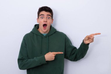 isolated teen boy pointing surprised