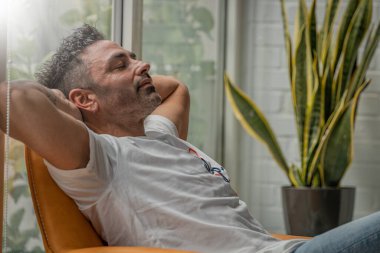 Genç adam evde kanepede rahatlatıcı