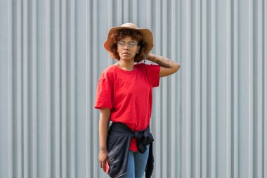 african american hipster girl with hat isolated on street wall