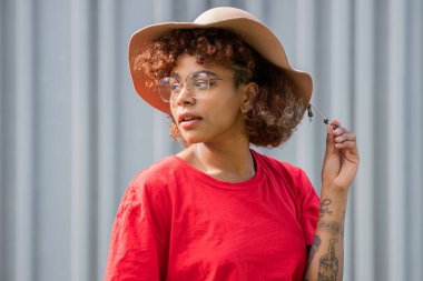 african american hipster girl with hat isolated on street wall