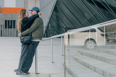 Bir çift erkek ve kız sokakta sarılıyorlar.