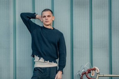 Bisikletli genç adam sokak duvarı arka planı ve fotokopi alanı ile rahat