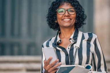 Cep telefonu ve haritası olan turist bir kadın.