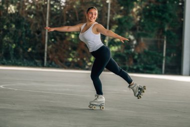 Genç kadın antrenman yapıyor ya da dışarıda spor yapıyor, patenci.