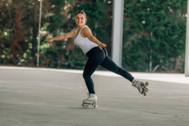 Genç kadın antrenman yapıyor ya da dışarıda spor yapıyor, patenci.