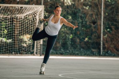 Genç kadın antrenman yapıyor ya da dışarıda spor yapıyor, patenci.