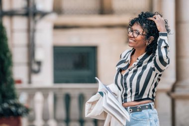 Afro-Amerikan Latin kadın şehir sokaklarında seyahat haritası taşıyor.