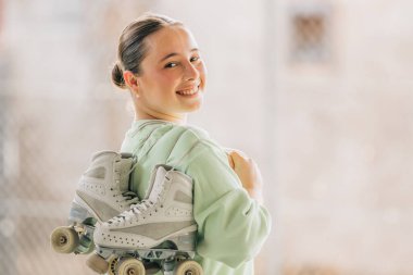 Patenleriyle dışarıda gülümseyen artistik patinaj sporcusu