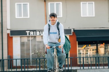 Bisiklet süren genç bir adam ya da öğrenci.