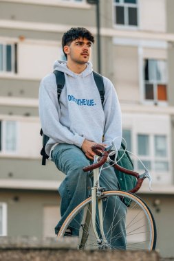 Sokakta dikey bisiklet süren genç bir adam ya da öğrenci.