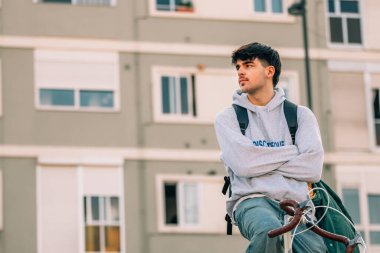 Genç bir adam ya da öğrenci klasik bisiklete biniyor.