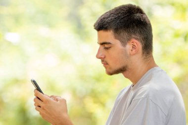 Cep telefonu ve cep telefonu olan genç bir adam.