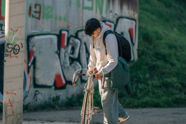 Sokakta bisiklet süren genç bir adam.