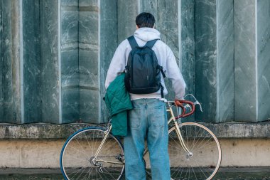 Klasik bisiklet ve fotokopi mekanıyla sokak duvarındaki genç adam.
