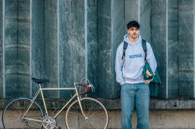 Klasik bisiklet ve fotokopi mekanıyla sokak duvarındaki genç adam.