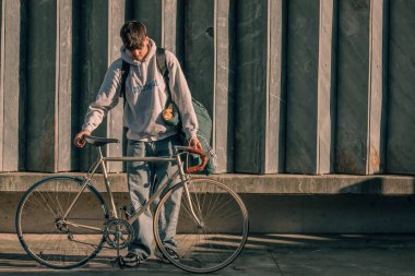 Sokaktaki genç adam, duvarında kopyalanmış eski bir bisikletle