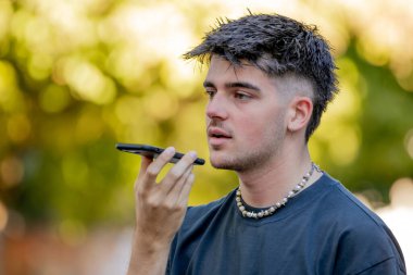 Cep telefonlu genç adam sesli veya sesli mesaj kaydediyor